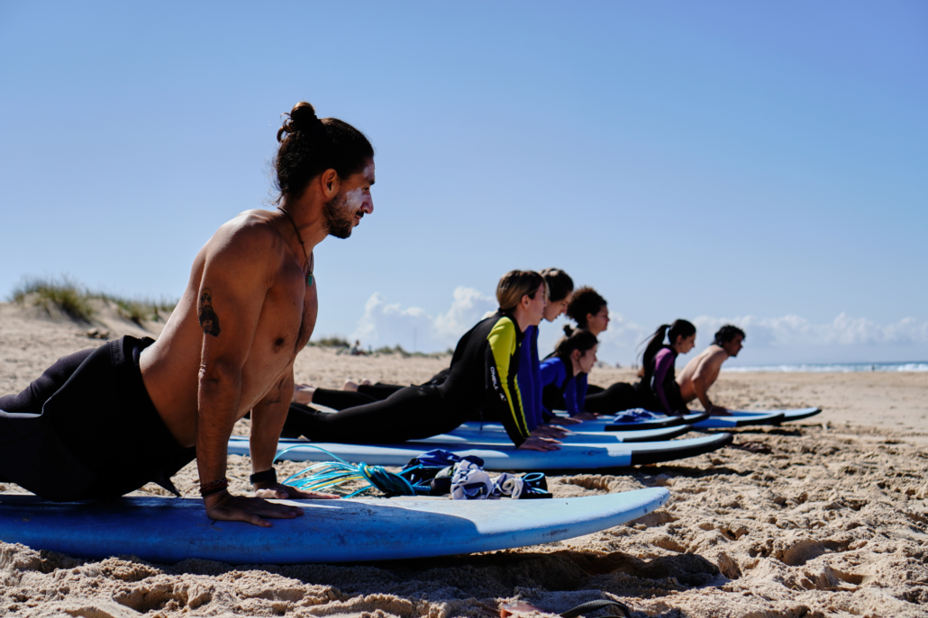 Grupo de surfers calentando antes de entrar al agua en el surfcamp de Nexo Surfhouse