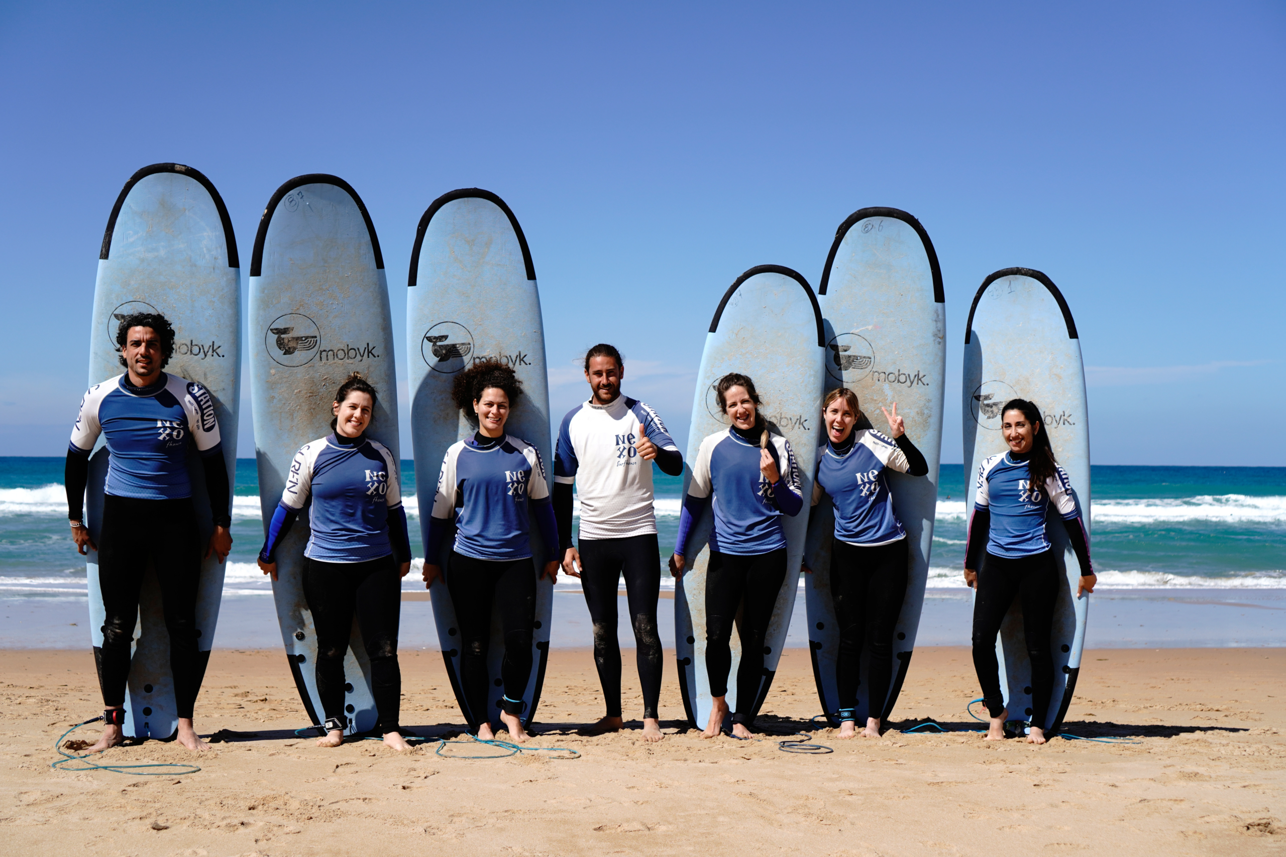 Grupo de adultos con tablas de surf durante un surf camp en El Palmar