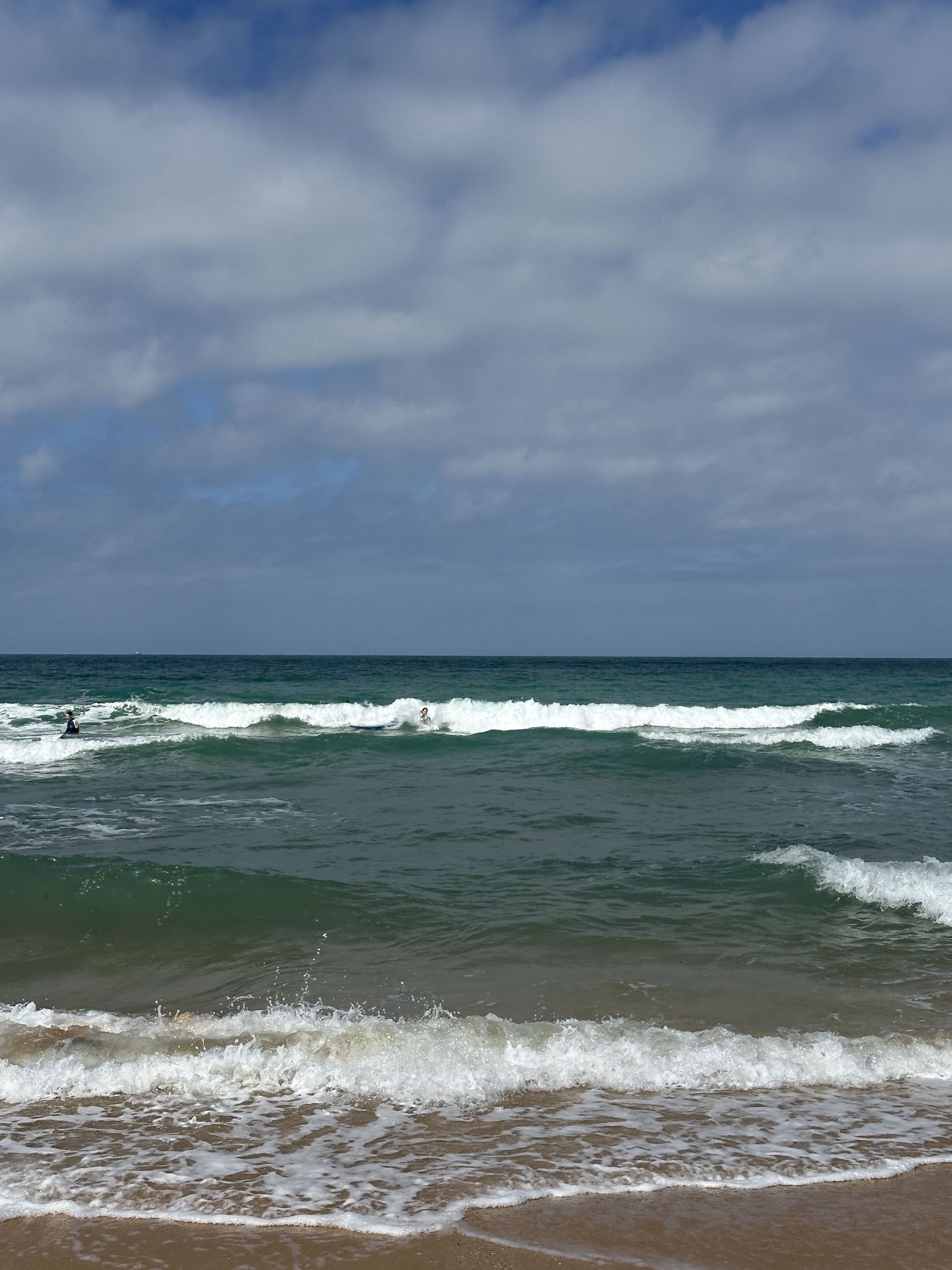 Olas en El Palmar en septiembre, surfista cogiendo ola