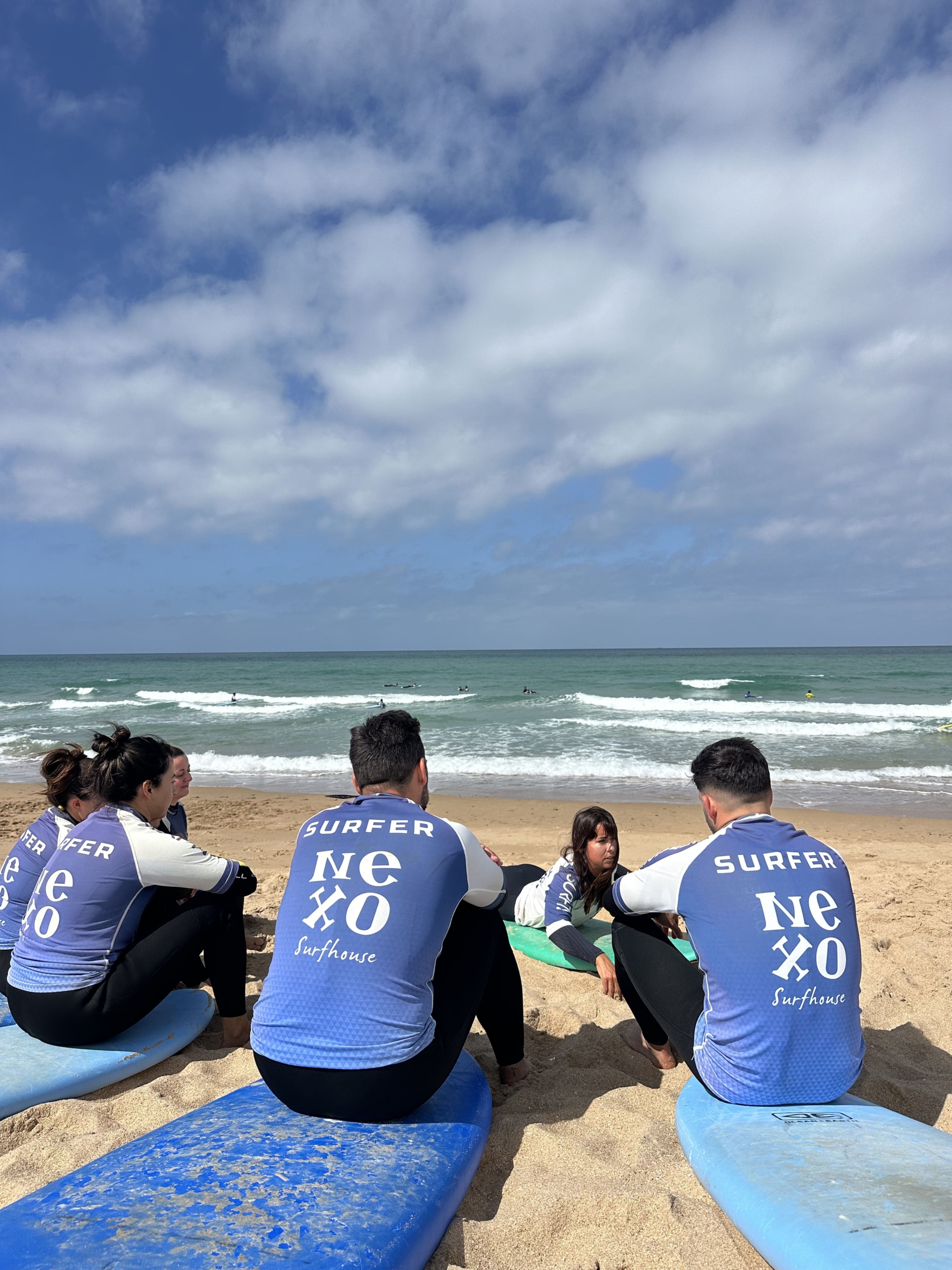Alumnos de surf de Nexo Surfhouse observando las olas en El Palmar