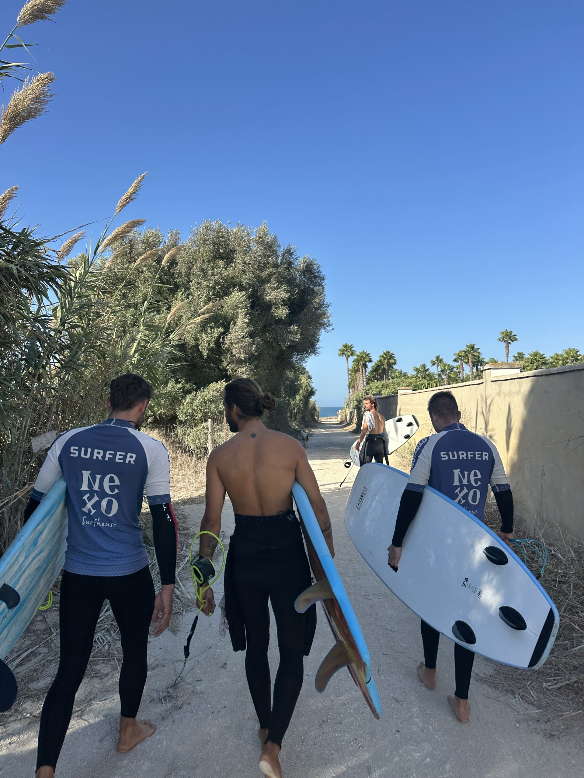 Surfistas de Nexo Surfhouse de camino a la playa de El Palmar