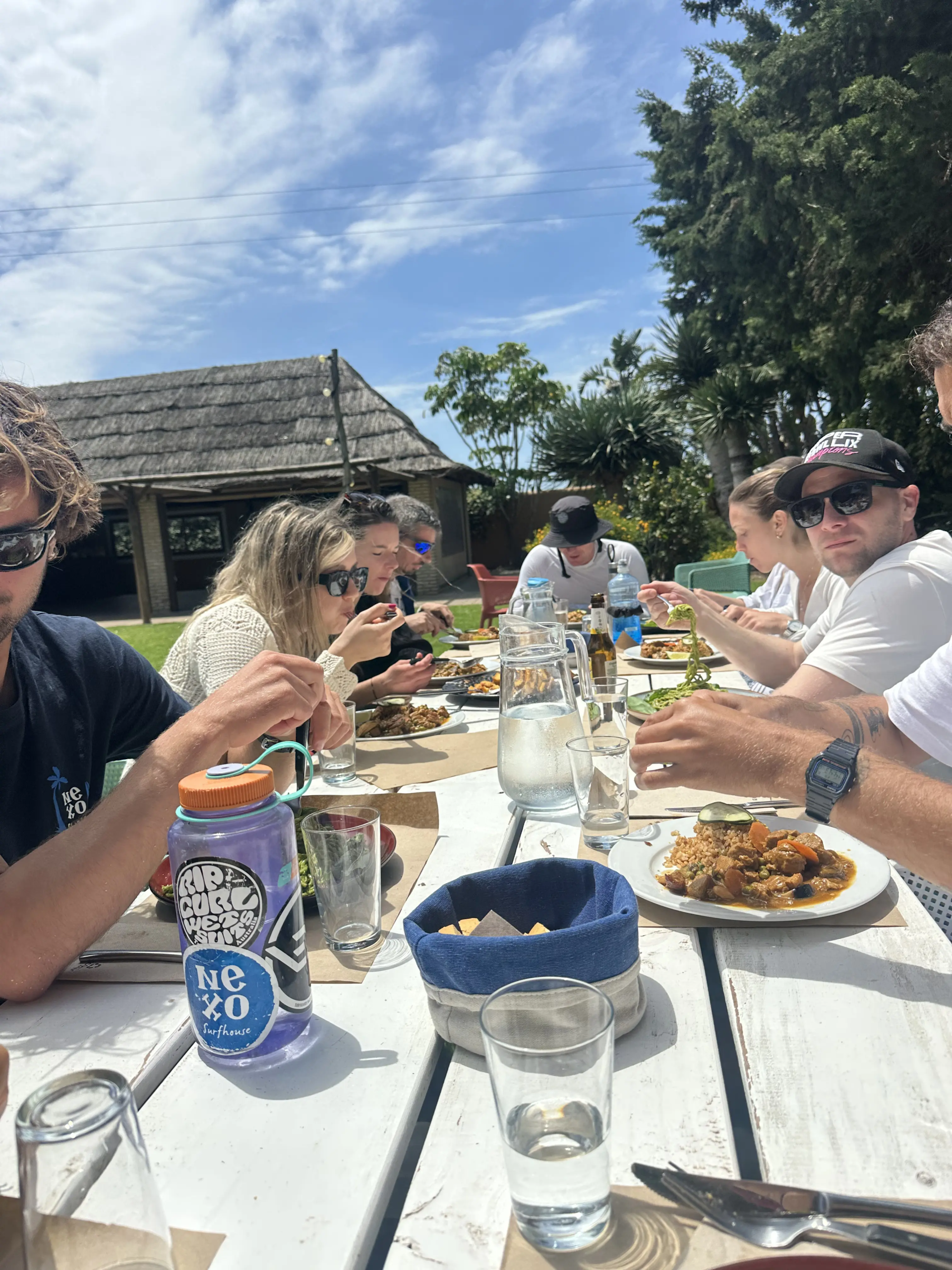 Grupo compartiendo una comida al aire libre en NEXO Surfhouse